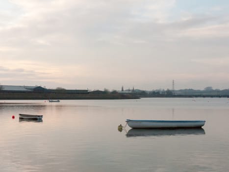 sunset over coast ocean bay water sky sea boats docks moored; essex; england; uk