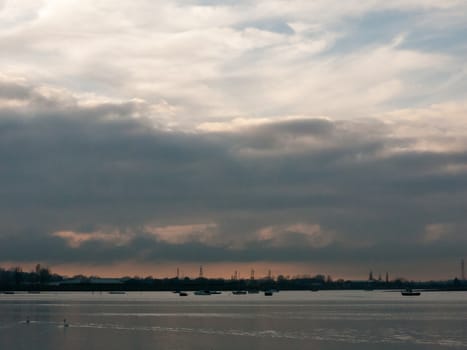 sunset over coast ocean bay water sky sea boats; essex; england; uk