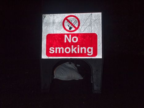 street sign construction night time no smoking red and white; essex; england; uk