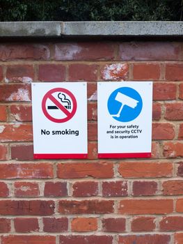 two signs at train station cctv no smoking; essex; england; uk