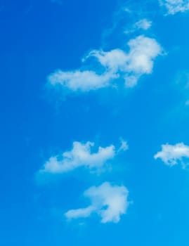 Deep blue bright sky with white fluffy clouds