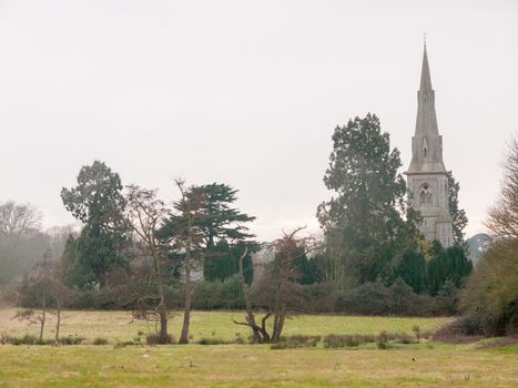 Mistley christian church as seen from over a field with trees in spring; essex; england; uk