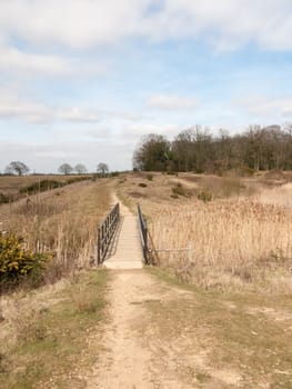 open landscape scene nature reserve with wooden foot bridge; essex; england; uk fields