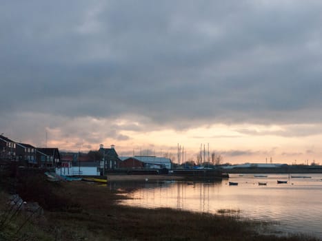 sunset over coast ocean bay water sky sea boats docks; essex; england; uk