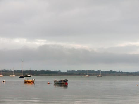 sunset over coast ocean bay water sky sea boats docks moored; essex; england; uk