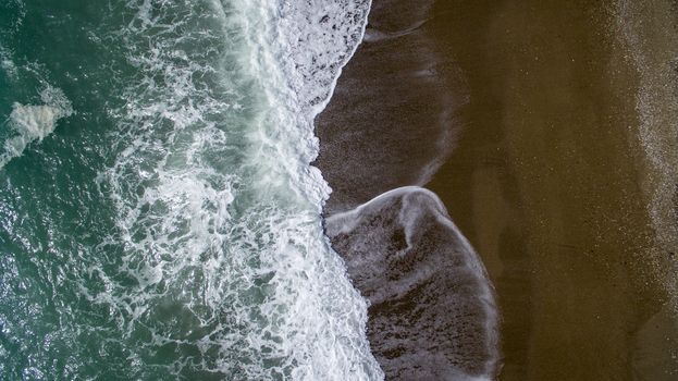 Aerial view waves break on white sand beach. Sea waves on the beautiful beach aerial view drone