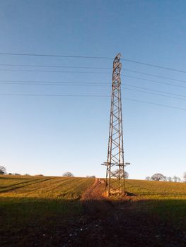 large metal tower field farm blue sky electric pylon communication power supply background; essex; england; uk