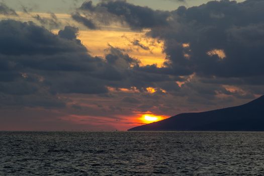 Nature in twilight period which including of sunrise over the sea and the nice beach. Summer beach with blue water and purple sky at the sunset.