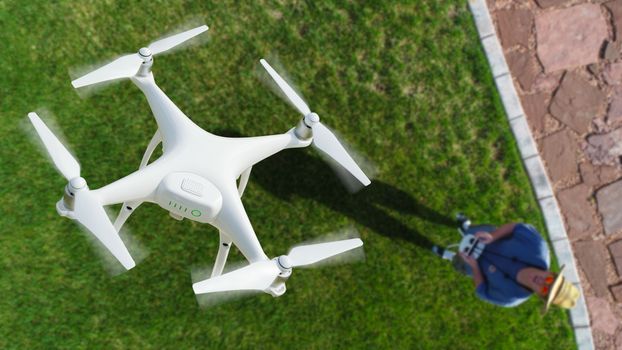 Drone Quadcopter (UAV) In Air Above Pilot With Remote Controller.