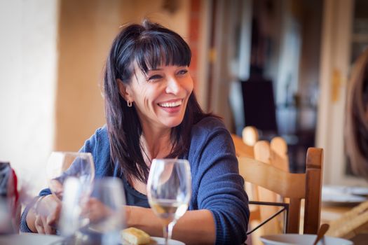 Pretty Italian Woman Enjoys A Meal And Drinks with Friends at Outdoor Restaurant.