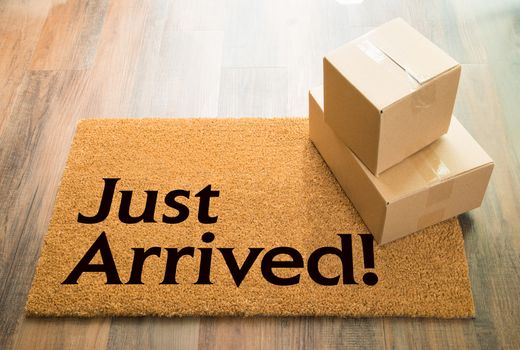 Just Arrived Welcome Mat On Wood Floor With Shipment of Boxes.