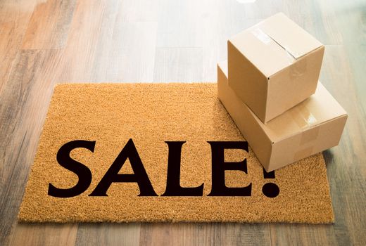 Sale Welcome Mat On Wood Floor With Shipment of Boxes.