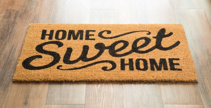 Home Sweet Home Welcome Mat On Wood Floor.