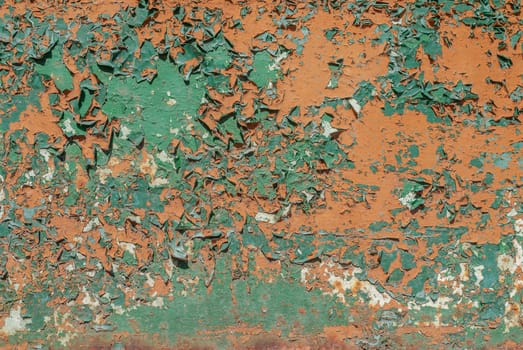 fragment of a rusty iron surface covered with old paint, which has long been under the influence of different climatic conditions