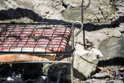 typical Abruzzo sausage grilled on fire in the woods in italy