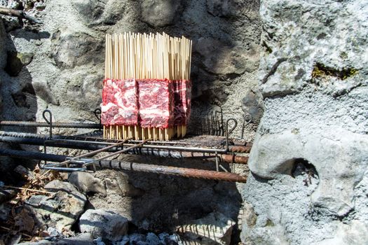 Arrosticini on the grill vertical cooking, Abruzzi skewers of sheep.