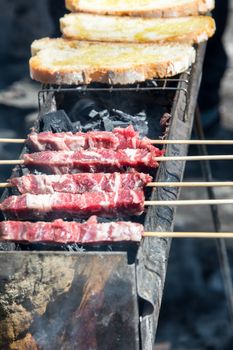 Arrosticini and bread on the grill, Abruzzi skewers of sheep cooked on the grate and on a special brazier.