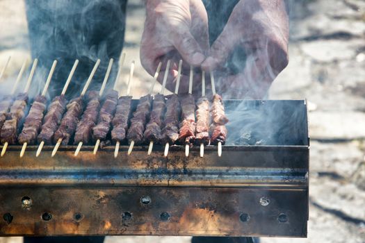 Arrosticini on the grill while turning, Abruzzi skewers of sheep cooked on the grate and on a special brazier.