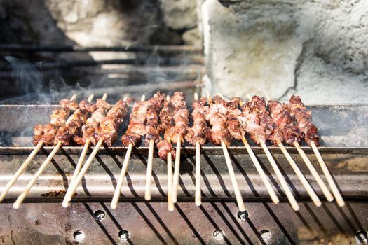 Arrosticini on the grill while turning, Abruzzi skewers of sheep cooked on the grate and on a special brazier.