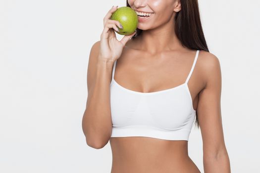 Attractive smiling woman portrait on white background with apple.