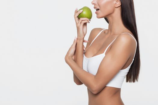 Attractive smiling woman portrait on white background with apple.