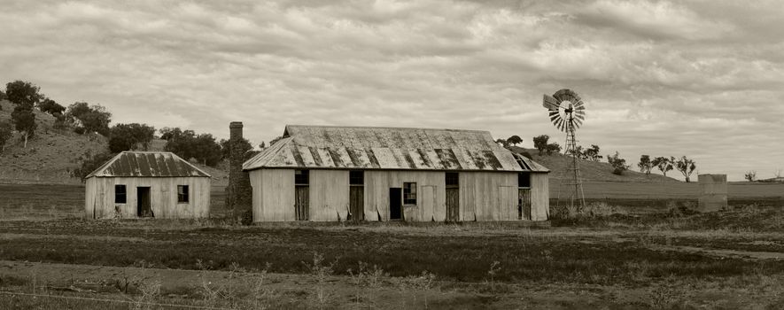 Rural farmlands with  rusty corrugated tin outbulldings sheds and windmill 