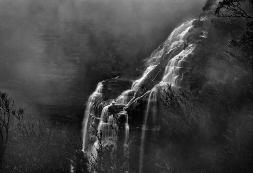 Wentworth Falls tumbling into the valley as a thick misty fog rolls in