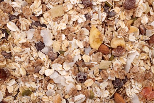 Background of muesli - cereal flakes with seeds, mixed fruit and nuts - as an abstract background texture - close detail