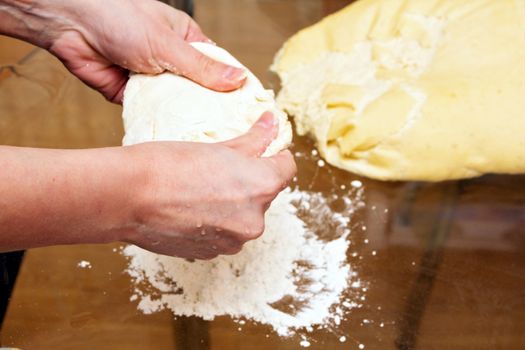 Woman hands forming yeast dough for pies.