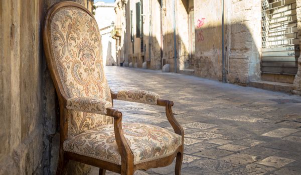 Lecce town, Italy. Vintage chair with old town street in background.