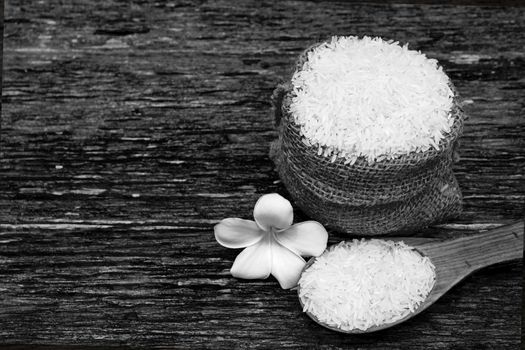 White uncooked rice with White uncooked  rice on wooden spoon, Thai rice on wooden background