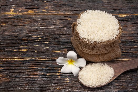 White uncooked rice with White uncooked  rice on wooden spoon, Thai rice on wooden background