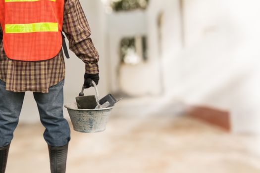 Engineer or safety officer holding bucket in the building is background in construction site.