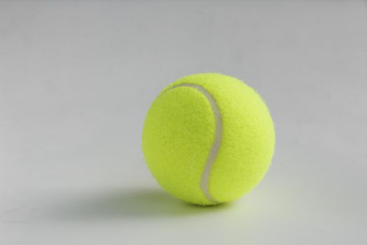 Single yellow tennis ball on the background close up