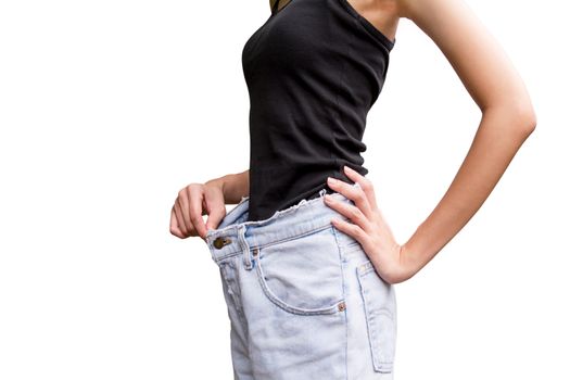 Young slim woman in oversize pair of blue jeans over white background.