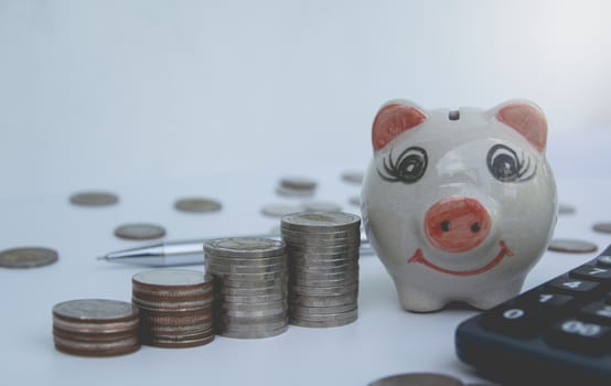 stack coins, calculator with piggy bank. Financial and saving concept.