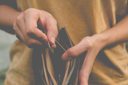 Close-up woman standing and holding money coin with wallet empty of money