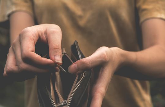 Close-up woman standing and holding money coin with wallet empty of money