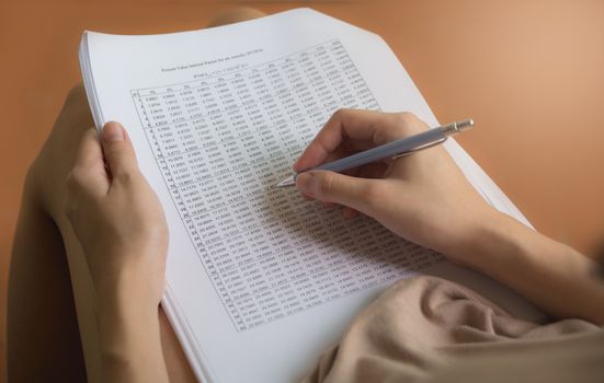 Woman sitting and holding a blue pencil and doing an exam