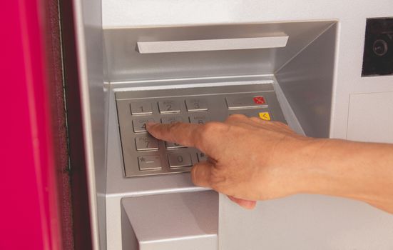 Hand of a woman push button in ATM, using an ATM. Woman using an ATM machine.