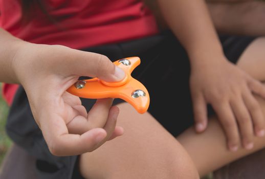 Children play with finger spinner gadget.Popular spinner device to play balance game.