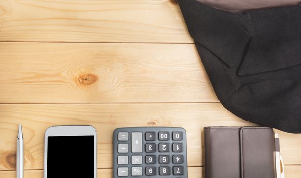 Office table with pen, wallet, calculator, suit and smart-phone. View from above with copy space.