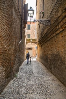 Ancient and narrow medieval street in Ferrara, Italy