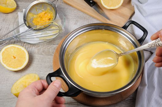 Freshly prepared lemon kurd - custard on fruit juice, in a saucepan stir with a spoon