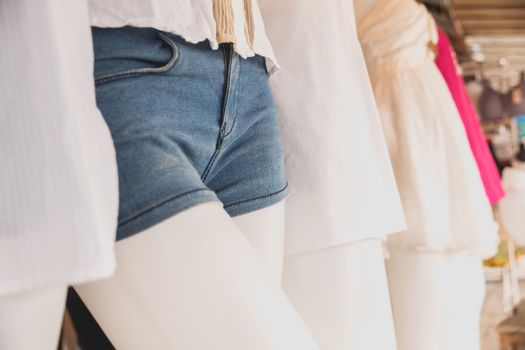 collection of jeans shorts. Modern torn blue jeans shorts on mannequin model.