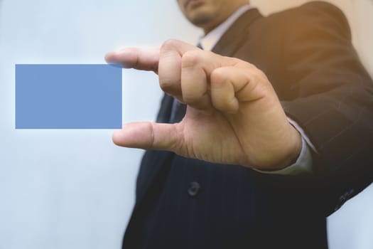 Hand of businessman holding the blue card on background.