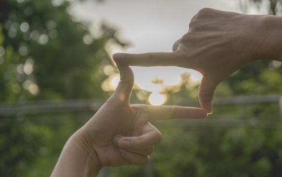 Close up of hands making frame gesture. Close up of woman hands making frame gesture with sunset.