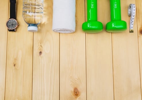 concept preparing to fitness sports equipment top view on wooden background.