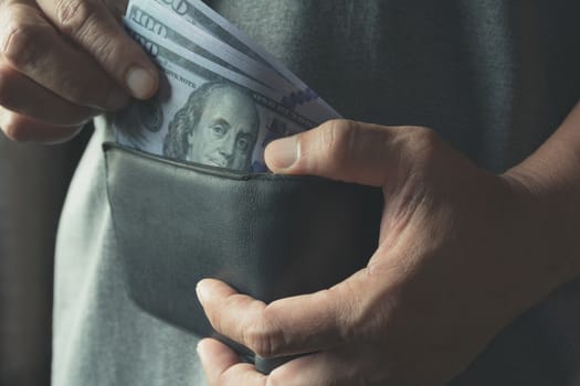 Male holding banknote in wallet in his hand for financial and saving money concept.