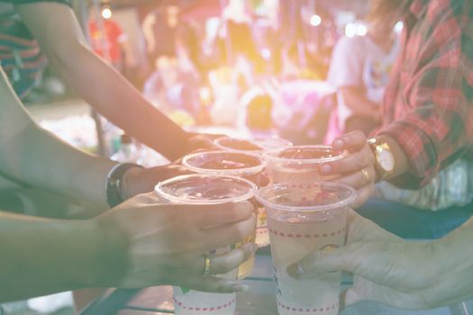 Friends clinking glasses above table.People holding glasses. cheering and celebration concept.